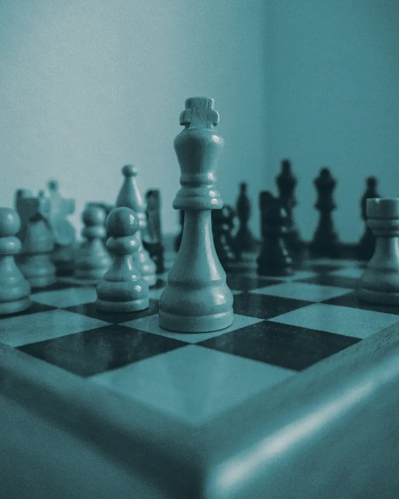 A chess king in the foreground of a board, toned in NEXM teal: the one move that matters